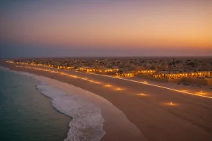 Des propriétés au bord de la plage à Dakhla brillant sous le coucher de soleil doré marocain, avec une architecture contemporaine intégrée au paysage désertique séduisant, une composition épique.