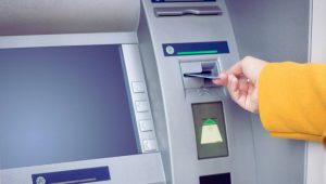 Une personne qui retire de l'argent un distributeur de billet