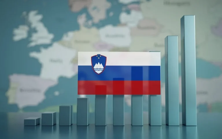 Drapeau slovène posé sur un graphique en barres croissantes devant une carte floue de l’Europe.